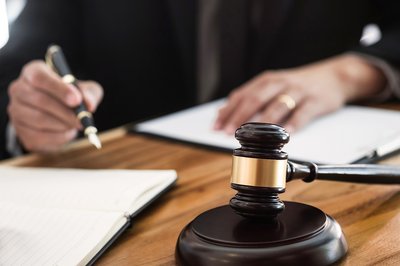 Wer rechtssicher handeln will, sollte bei aktuellen Urteilen auf dem Laufenden bleiben, Foto: Adobe Stock/Memyjo Richter beim Unterschreiben eines Urteils