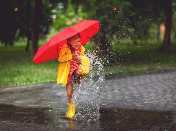 Kind spielt im Regen