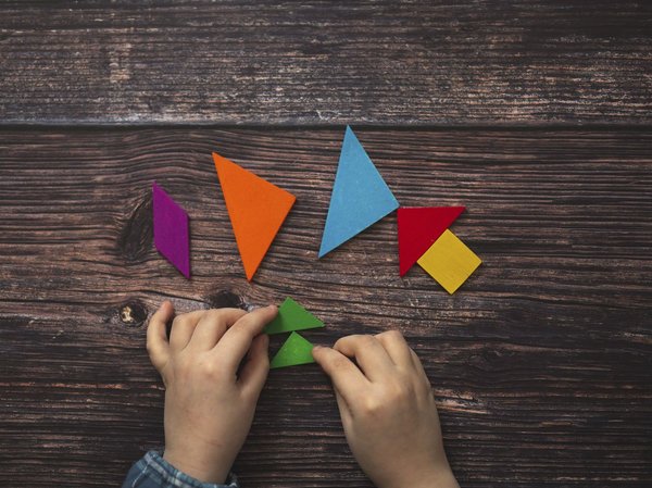 Ein Kind legt Tangram-Elemente